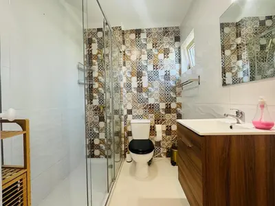 a bathroom with a toilet and a glass shower at Doble Vista Faro, Terrace with View, AC & WiFi in Faro