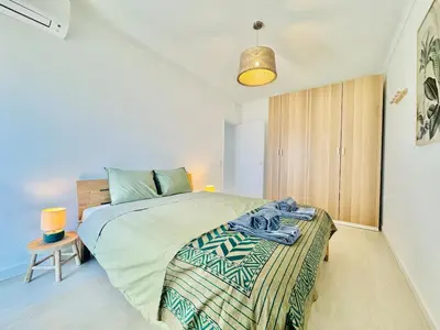 a bedroom with a large bed and a lamp at Doble Vista Faro, Terrace with View, AC & WiFi in Faro