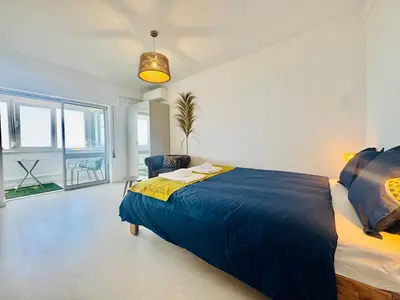 a bedroom with a large bed and a large window at Doble Vista Faro, Terrace with View, AC & WiFi in Faro