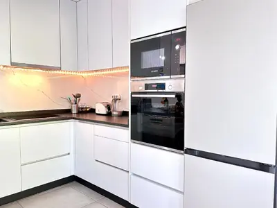 a white kitchen with white cabinets and appliances at Windmill Hill Gem Townhouse By BeCherish in Albufeira