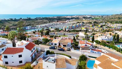 an aerial view of a town with houses and the ocean at Windmill Hill Gem Townhouse By BeCherish in Albufeira