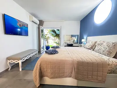 a bedroom with a large bed and a large window at Windmill Hill Gem Townhouse By BeCherish in Albufeira