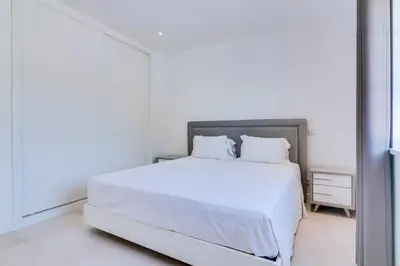 a white bedroom with a large white bed with white pillows at Casa Nuria com 4 quartos, piscina e churrasco em Vale do Lobo in Almancil