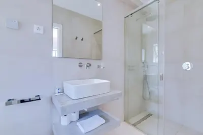 a white bathroom with a sink and a shower at Casa Nuria com 4 quartos, piscina e churrasco em Vale do Lobo in Almancil