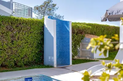 a building with blue tiles on the side of a hedge at Casa Nuria com 4 quartos, piscina e churrasco em Vale do Lobo in Almancil