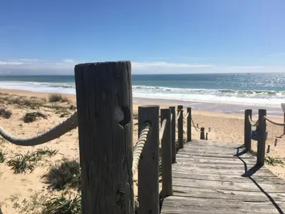 a wooden boardwalk leading to the beach at Casa Sauchi mit Gemeinschaftspool - Neu renoviert in Albufeira
