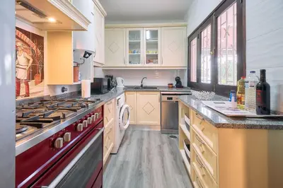 a large kitchen with a red stove top oven at Casa Sauchi mit Gemeinschaftspool - Neu renoviert in Albufeira
