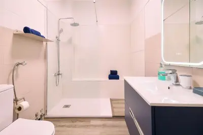 a white bathroom with a shower and a sink at Casa Sauchi mit Gemeinschaftspool - Neu renoviert in Albufeira