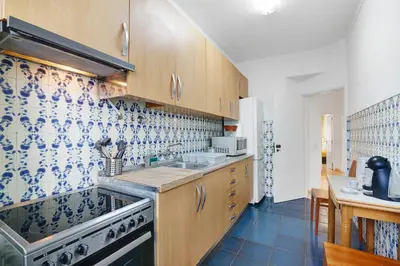 a kitchen with a sink and a stove at Happy House Central Apartment in Faro
