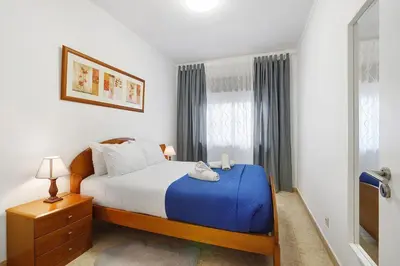 a bedroom with a bed with a blue blanket at Happy House Central Apartment in Faro