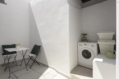 a laundry room with a washing machine and a table at Marggisa - City Center by HD in Faro