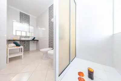 a white bathroom with a shower and a toilet at Villa Mare in Albufeira