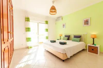 a bedroom with a large bed with green walls at Villa Mare in Albufeira