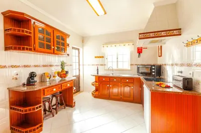 a large kitchen with wooden cabinets and counter tops at Villa Mare in Albufeira