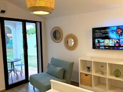 a living room with a couch and a flat screen tv at Refúgio junto à falésia in Olhos de Água
