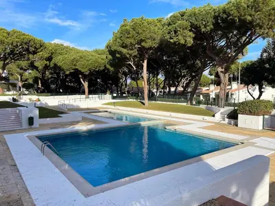 a swimming pool in a park with trees in the background at Refúgio junto à falésia in Olhos de Água