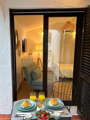 a table with plates of food and two glasses of orange juice at Refúgio junto à falésia in Olhos de Água