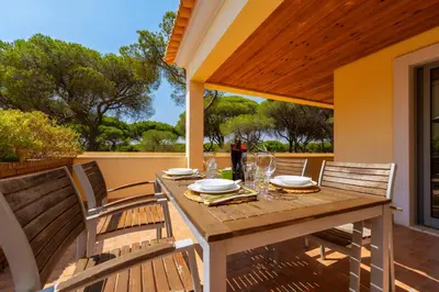 a wooden table and chairs on a porch with a table and chairsktop at 3 Quartos, Piscina, AC, Garagem, Prestige For Home in Faro