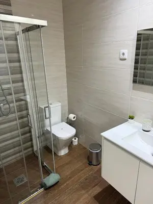 a bathroom with a toilet and a glass shower at Albufeira Solmare Suites in Albufeira
