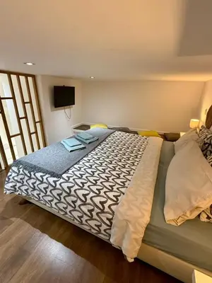 a bedroom with a large bed with a tv on the wall at Albufeira Solmare Suites in Albufeira