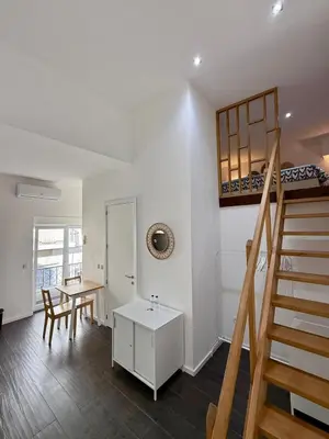 a living room with a staircase and a table at Albufeira Solmare Suites in Albufeira