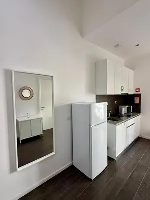 a kitchen with white cabinets and a refrigerator at Albufeira Solmare Suites in Albufeira