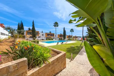 a resort with a swimming pool and palm trees at Apartamento Vista Piscina in Guia