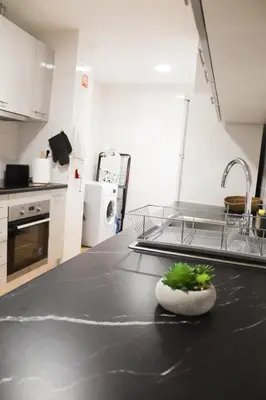 a kitchen with a black counter top with a sink at Luxury Apartment in Vila Sol Resort in Quarteira