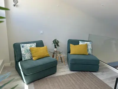 two chairs with yellow pillows in a living room at Villa Soligolf - Vilamoura, Algarve in Quarteira