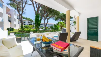 a glass table with a bowl of fruit on a balcony at Lounge Garden Apartment in Vilamoura