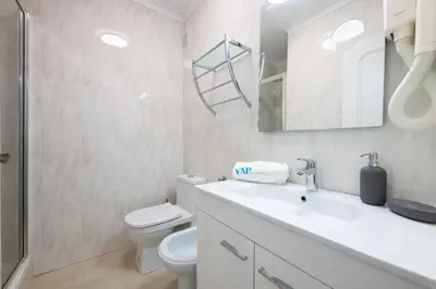 a white bathroom with a toilet and a sink at Lounge Garden Apartment in Vilamoura