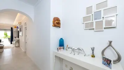a white hallway with a white wall with pictures on it at Lounge Garden Apartment in Vilamoura