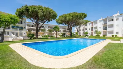 a swimming pool in front of a building at Lounge Garden Apartment in Vilamoura