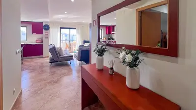 a living room with a counter with two vases with flowers at Ocean View Quarteira in Quarteira