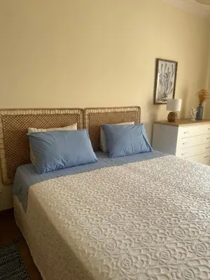 a bedroom with a bed with two blue pillows at Jardins da Marina BQ in Albufeira