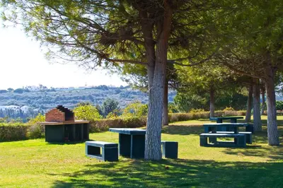 a park with three picnic tables and a tree at Jardins da Marina BQ in Albufeira