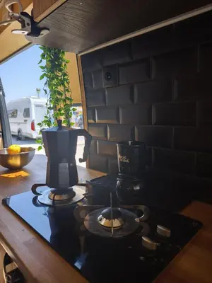 a kitchen counter with a stove with a pot on it at Tiny House na Praia de Faro Experiencia Glamping in Faro