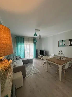 a living room with a couch and a table at Beach House in Quarteira