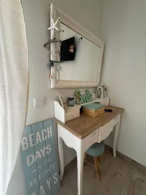 a desk with a mirror and a chair in a room at Beach House in Quarteira