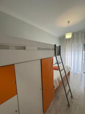 a bedroom with a bunk bed and a ladder at Beach House in Quarteira