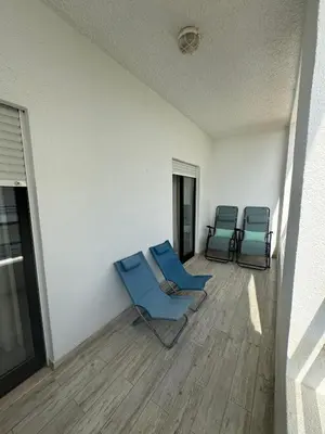 two blue chairs sitting in a room with a floor at Beach House in Quarteira