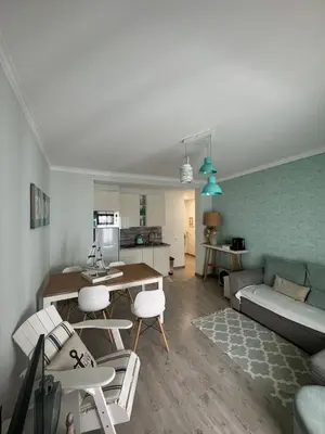 a living room with a couch and a table and chairs at Beach House in Quarteira