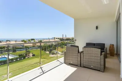 a balcony with two chairs and a view of the ocean at Snazzy Varandas do Castelo One Bedroom Apartment with Sea View sleeps 2 in Albufeira