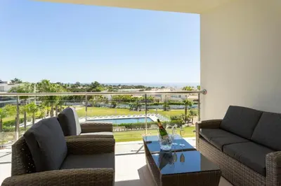 a living room with two couches and a glass table at Snazzy Varandas do Castelo One Bedroom Apartment with Sea View sleeps 2 in Albufeira