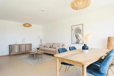 a living room with a wooden table and blue chairs at Snazzy Varandas do Castelo By Garvetur One Bedroom Apartment sleeps 2 persons in Albufeira