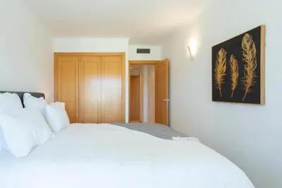 a bedroom with a white bed and a picture on the wall at Snazzy Varandas do Castelo - One Bedroom Apartment sleeps 2 person in Albufeira