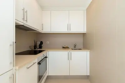a white kitchen with white cabinets and a sink at Snazzy Varandas do Castelo - One Bedroom Apartment sleeps 2 person in Albufeira