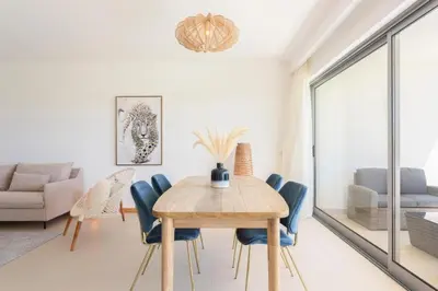 a dining room with a wooden table and blue chairs at Snazzy Varandas do Castelo - One Bedroom Apartment sleeps 2 person in Albufeira