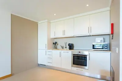a kitchen with white cabinets and a microwave at Snazzy Varandas do Castelo One Bedroom Apartment with Sea View sleeps 2persons in Albufeira