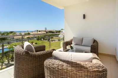 a balcony with wicker chairs and a table with a view at Snazzy Varandas do Castelo One Bedroom Apartment with Sea View sleeps 2persons in Albufeira
